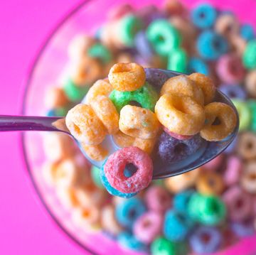 fruity cereal on a spoon above a bowl fruity cereal on a spoon above a bowl