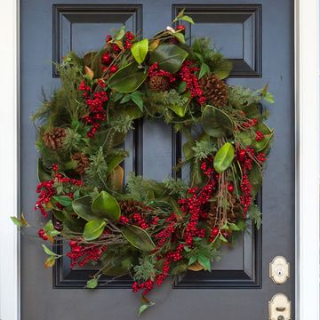 christmas wreath on front door, poinsettia and tree on stoop