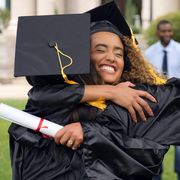 graduate hugs friend post ceremony