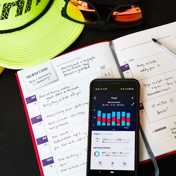 fitness journal, running hat and sunglasses with food tracker app on phone fitness journal, running hat and sunglasses with food tracker app on phone