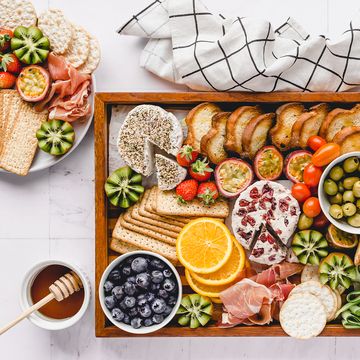 cheese fruit cracker olives on wooden tray
