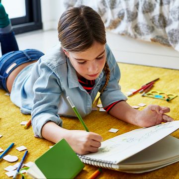 young girl on floor drawing with color pencils young girl on floor drawing with color pencils