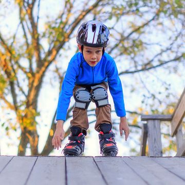 boy roller blading with helmet and knee pads boy roller blading with helmet and knee pads