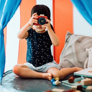 2 year old playing in play tent with camera blocks and books 2 year old playing in play tent with camera blocks and books