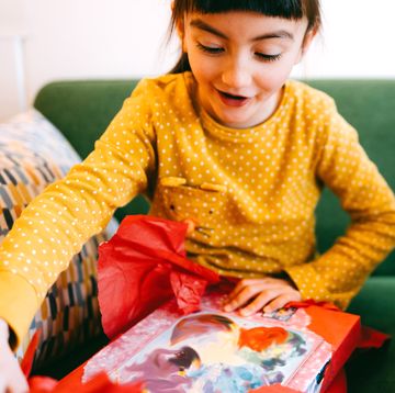 7 year old girl opening up gift