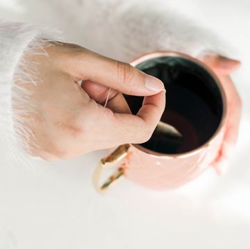 woman with fuzzy sweater steeping tea in copper mug woman with fuzzy sweater steeping tea in copper mug