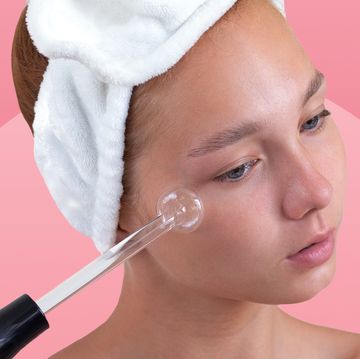 woman using high frequency wand on cheek