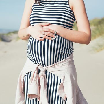 pregnant woman in striped maternity dress at beach