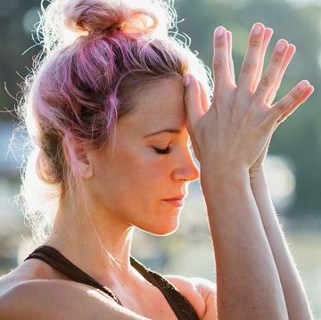 woman with pink hair and wearing workout clothes doing meditation outside woman with pink hair and wearing workout clothes doing meditation outside