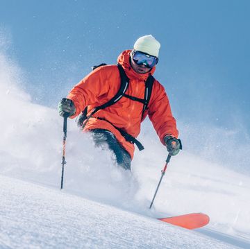 man in orange jackets skiing man in orange jackets skiing