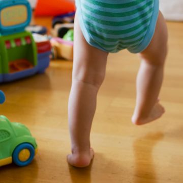 baby walking next to toys baby walking next to toys