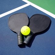 pickleball paddles and yellow ball on court pickleball paddles and yellow ball on court