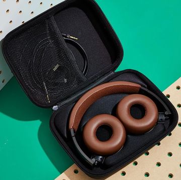 status audio headphones against pegboard and in case