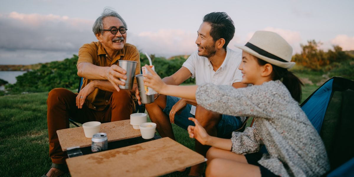 family having a toast at campsite at dusk