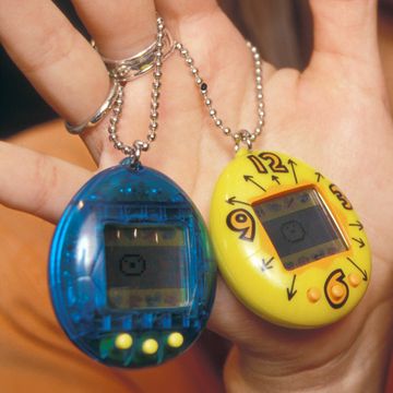 person holding four tamagotchis on hands